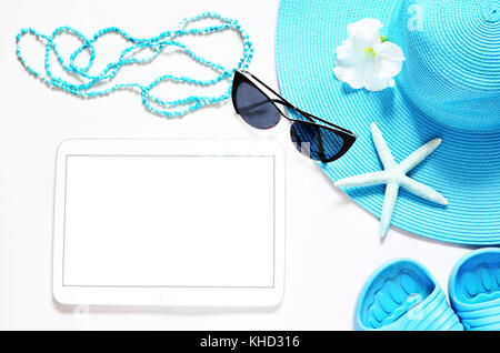 Tablet with blank screen on white surface with beach items, top view. Stock Photo
