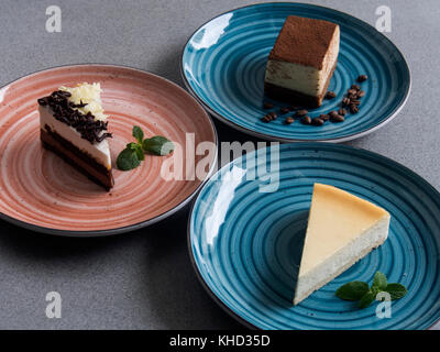 Set of various cakes on plates on grey background Stock Photo