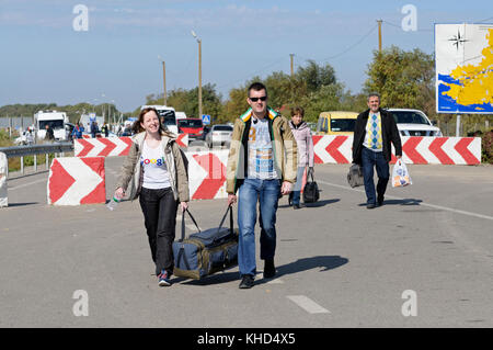 Man and woman with a bag in hands crossing Ukrainian-Russian border at the border crossing point Kalanchak. September 20, 2017. Ukraine Stock Photo