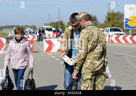 Border guard checking traveler’s passport at the border crossing point Kalanchak. September 20, 2017. Kalanchak region, Khersonskaya oblast, Ukraine Stock Photo