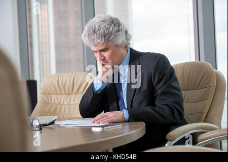 Mature business man works with docs Stock Photo