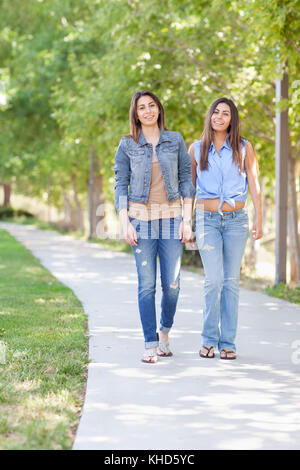 Two Beautiful Ethnic Twin Sisters Walking Outdoors. Stock Photo