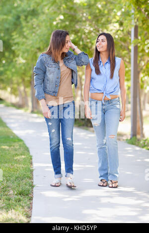 Two Beautiful Ethnic Twin Sisters Walking Outdoors. Stock Photo