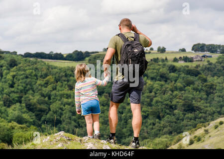 father and daughter looking down from Thorpe cloud, Derbyshire Stock Photo