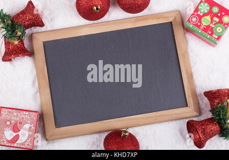 Christmas decorations and blank chalkboard on snow Stock Photo