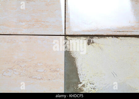 industrial construction worker installing small ceramic tiles on bathroom walls and applying mortar with trowel Stock Photo