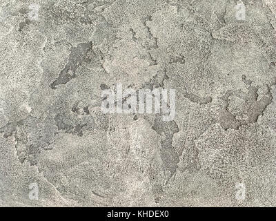 Old light brown wall covered with shabby uneven plaster. Texture of vintage gray stone surface, closeup. Stock Photo