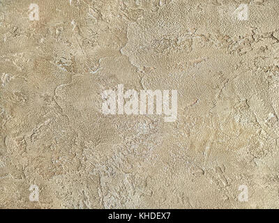 Old light brown wall covered with shabby uneven plaster. Texture of vintage sand stone surface, closeup. Stock Photo