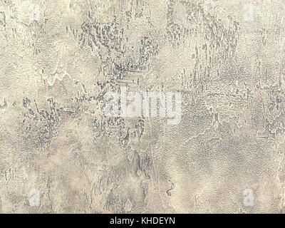 Old light brown wall covered with shabby uneven plaster. Texture of vintage beige stone surface, closeup. Stock Photo
