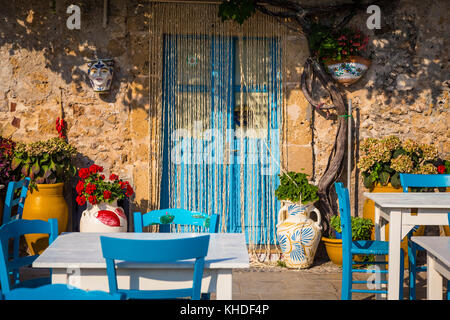 Tables and chairs setup in a traditional Italian restaurant in Marzamemi - Sicily during a sunny day Stock Photo