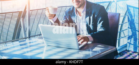 businessman working on computer, drinking coffee and smiling, abstract business banner background with place for text Stock Photo