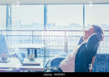 happy successful businessman relaxing in front of computer, entrepreneur dreaming and smiling Stock Photo