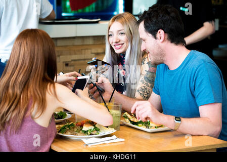 Friends chatting and using smart phones Stock Photo