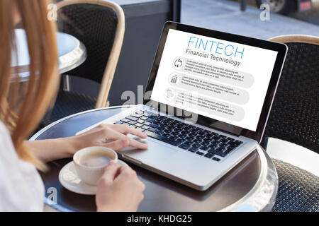 fintech concept, woman reading about financial technology on computer screen Stock Photo