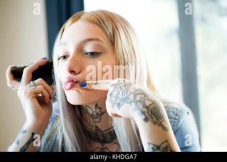 Young woman puckering lips while posing for a selfie Stock Photo