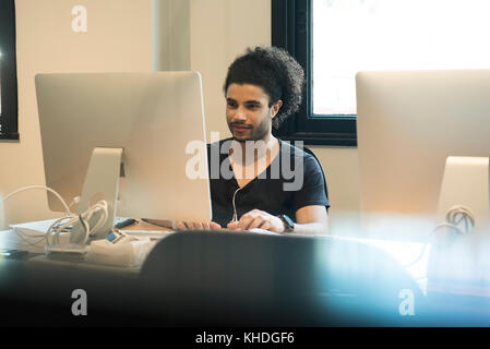 Young man using desktop computer Stock Photo