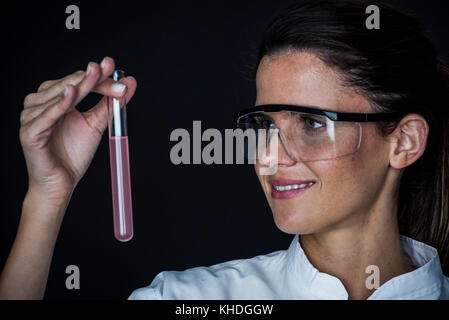 Young woman looking at liquid in test tube Stock Photo