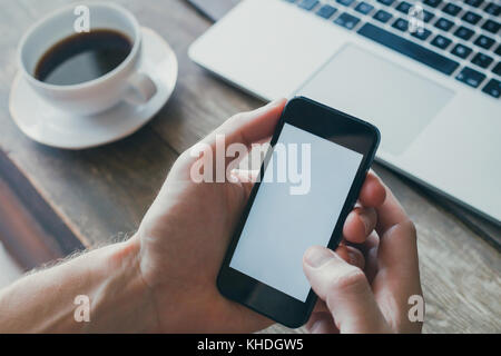 mobile app, closeup of hands holding smartphone with empty white screen Stock Photo