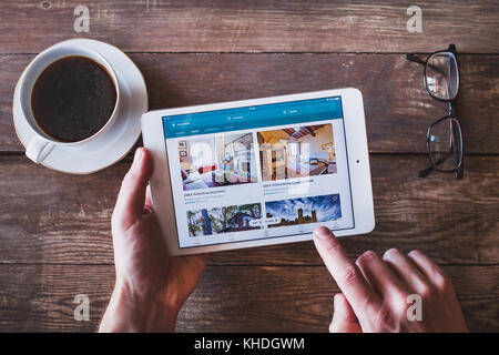 ANZERE, SWITZERLAND - SEPTEMBER 22 2017: Person using Airbnb app to book an apartment online on the screen of smartphone iPhone Stock Photo