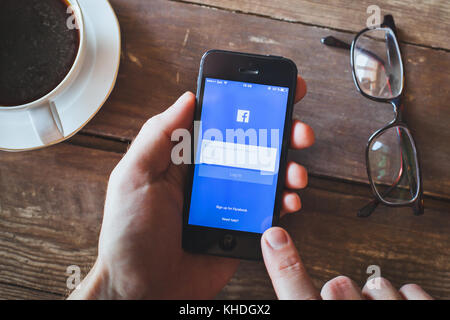 ANZERE, SWITZERLAND - SEPTEMBER 22 2017: Person using Facebook social network on the screen of smartphone iPhone, login page of app Stock Photo