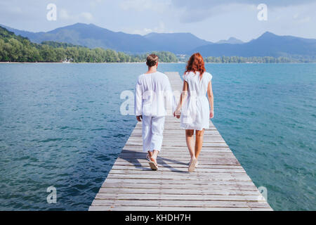 couple walking on wooden pier on the beach, beautiful honeymoon travel background