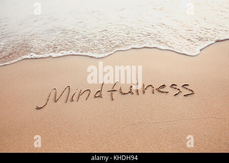 mindfulness concept, mindful living, text written on the sand of beach Stock Photo