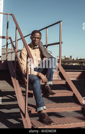 Stylish man sitting on stairs Stock Photo