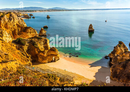 Wooden stairs leading to cliff hidden Praia do Camilo, Algarve, Portugal Stock Photo