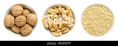 Whole walnuts, kernel halves and ground walnuts in white bowls on white background. Seeds of the common walnut tree Juglans regia. Photo. Stock Photo