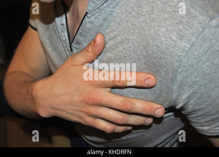 Young man having a heart attack Stock Photo
