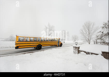 School bus driving along road after large snowfall in Clarington, ON, Canada Stock Photo