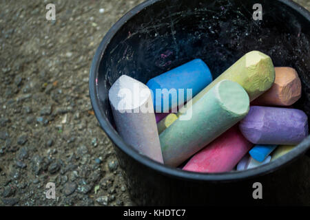 A bunch of thick colored chalks in a black plastic bucket Stock Photo