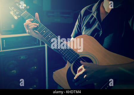 Closeup musician playing the guitar on band background with spot light, musical concept Stock Photo