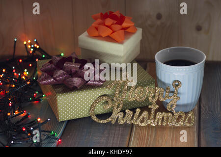 Two gift boxes, cup of coffee and Marry Christmas on the table   Stock Photo