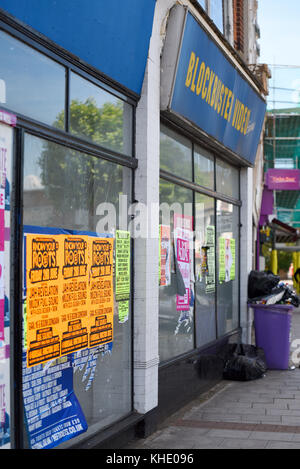 Old Blockbuster Video shop store still empty after closing down. Covered in advertising flyers. Urban decay. Rubbish, waste Stock Photo