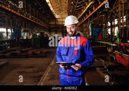 Worker in a helmet with a tablet Stock Photo