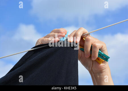 Woman hand washing and hanging up laundry outdoor in a sunny day. Woman  holding a tin bucket of water. Retro style Stock Photo - Alamy