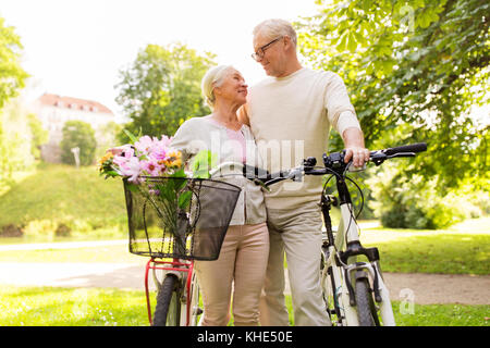 happy senior couple with bicycles at summer park Stock Photo