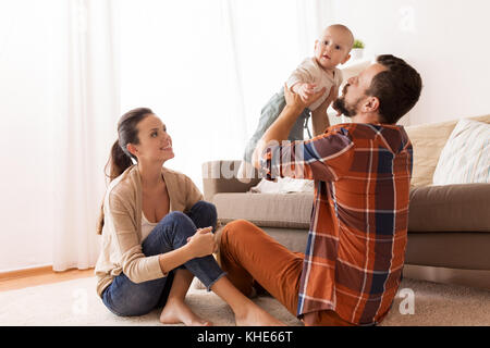 happy mother and father playing with baby at home Stock Photo