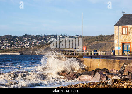 Waves breaking against the quay at Charmouth in Dorset. Stock Photo