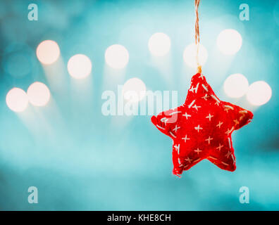 Christmas background with hanging red rag star and holiday bokeh Stock Photo