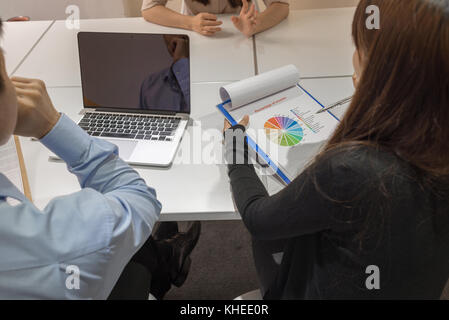 Two managers asking employee about sales report Stock Photo