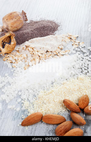 Various types of flours. Almond, rice, oat and poppyhead flour on wooden table. Stock Photo
