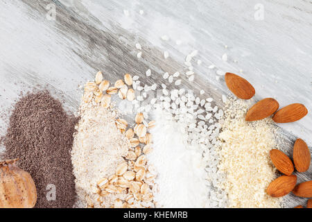Various types of flours on wooden table from above. Rice, almond, oat and poppy seed flour. Stock Photo