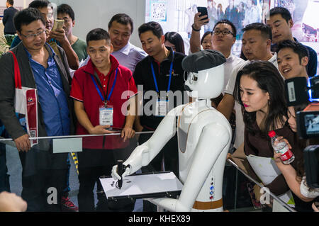 Intelligent AI drawing robot sketching pictures drawings likenesses of people through artificial intelligence at China hi-tech fair in Shenzhen, known as 'Silicon Valley of China', Shenzhen, China. Stock Photo