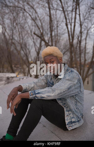 Young man sits on a rooftop Stock Photo