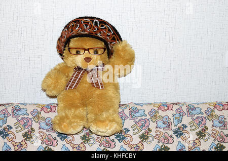 Yellow Teddy bear sits on the couch. Stock Photo