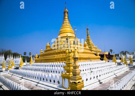 Golden Sandamuni Pagoda with row of white pagodas. Amazing architecture of Buddhist Temples at Mandalay. Myanmar (Burma) Stock Photo