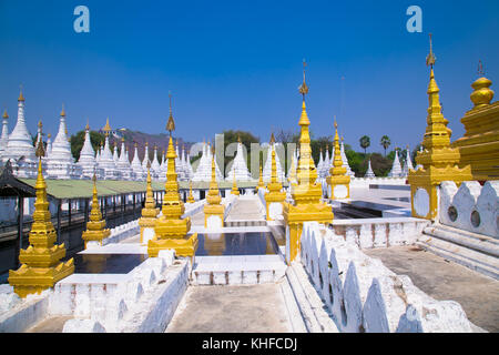 Golden Sandamuni Pagoda with row of white pagodas. Amazing architecture of Buddhist Temples at Mandalay. Myanmar (Burma) Stock Photo