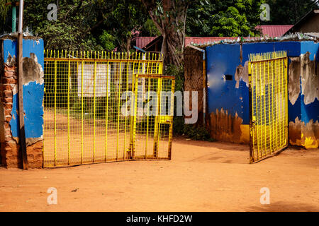 A very colorful gate on a dusty road nearby Mbale in Uganda Stock Photo
